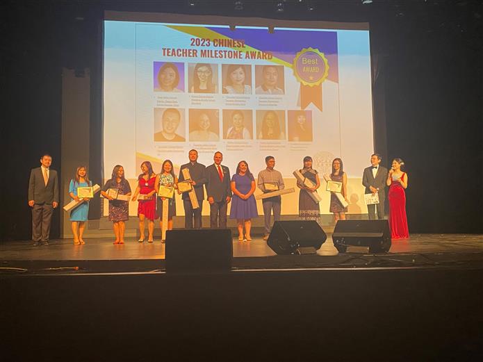 An image of all teachers honored on stage with the teacher milestone award